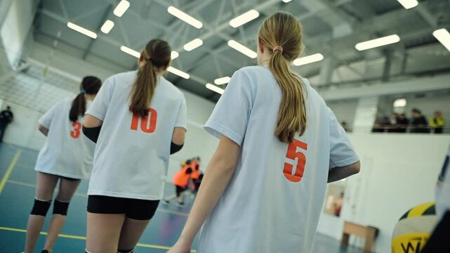 Competitive youth volleyball match showcasing teamwork and skill in a modern sports facility