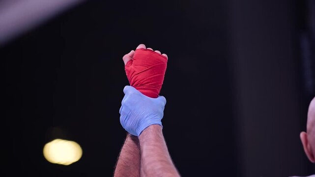 Close-up of the referee raising the hand of the boxer who won the fight.
