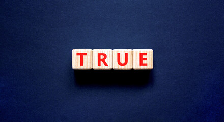 True symbol. Concept word True on beautiful wooden blocks. Beautiful black table black background....