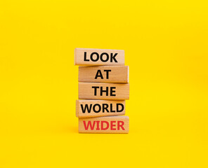 Look at the world wider symbol. Wooden blocks with words Look at the world wider. Beautiful yellow background. Business and Look at the world wider concept. Copy space.