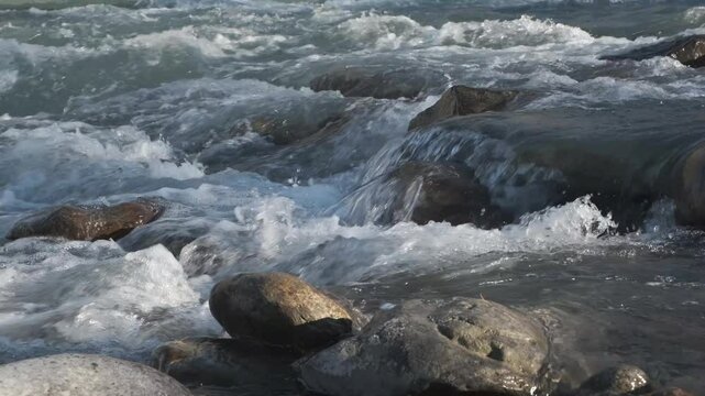  Mountain river running over stones in sunlight 
