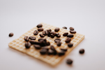 A beautiful combination of a waffle and coffee beans on a white background.