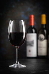 Red Wine in a Glass with Bottles and Grapes