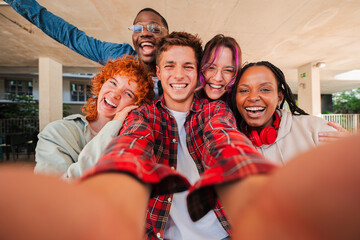 Joyful group of multiracial friends enjoying a fun selfie moment together, showcasing their...