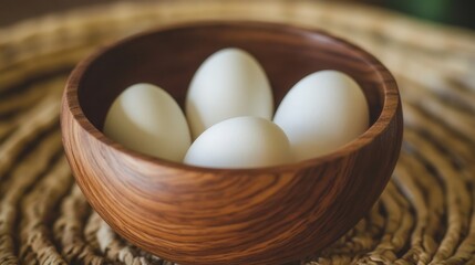 A close-up view of a rustic wooden bowl brimming with fresh eggs, elegantly positioned on a textured table surface.