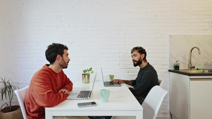 Gay couple working from home having a discussion
