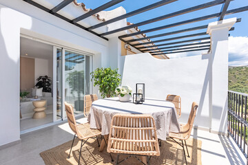 an image of a round outdoor dining table with wooden chairs on luxury apartment terrace 