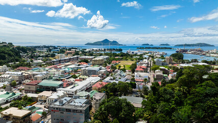Coastline showcasing industrial shipping port with surrounding buildings and water. Victoria. Seychelles, Mahe.