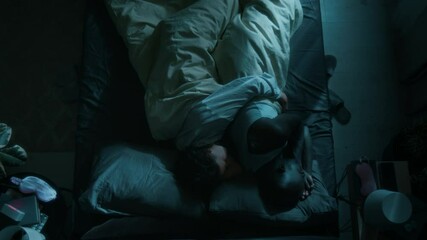 Top view shot of biracial couple hugging while sleeping in bed together at night in modern bedroom - Powered by Adobe