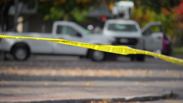  The bright yellow Crime Scene Do Not Cross tape stretched across an urban environment. Car accident