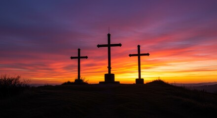 Obraz premium Three Crosses at Sunset - Silhouetted crosses stand against a vibrant sunset sky, creating a serene and spiritual