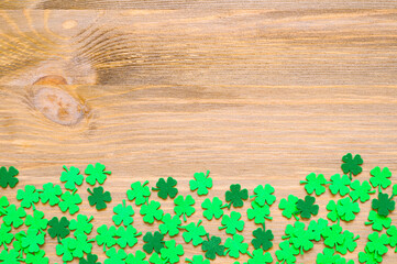 St Patrick's Day background with one side border of green quatrefoils on the wooden background,...