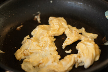 Close up of scrambled omelet egg in a black pan