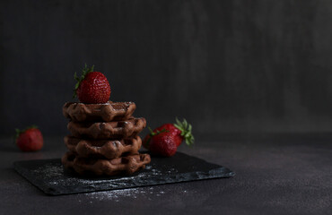 dessert pastry chocolate waffles with strawberries on a dark background