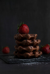 dessert pastry chocolate waffles with strawberries on a dark background