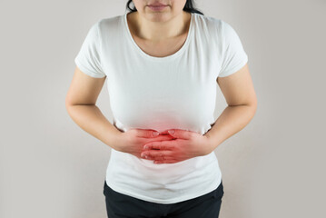 woman in white t-shirt suffers from stomach pain