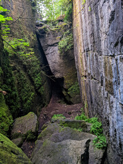 An open area in between large boulders covered in moss on the Niagara Escarpment. Along the Bruce Trail during summer in Ontario