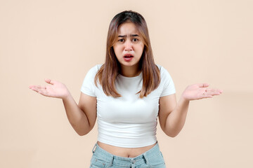 A young woman with a confused expression, raising her hands in a questioning gesture, set against a...