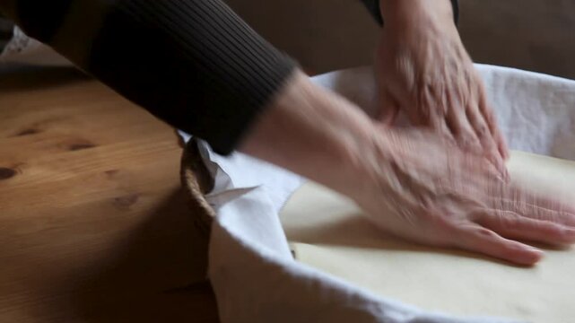 Woman making bread, close-up shot, kneading process.