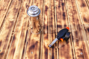 Gas cylinder and burner on the wooden background.