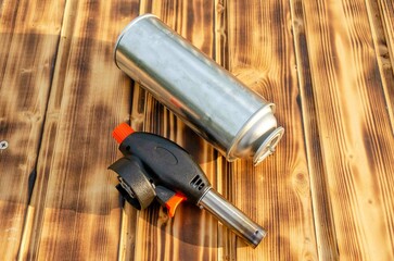 Gas cylinder and burner on the wooden background.