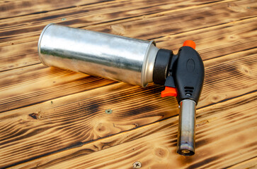Metal gas burner on the wooden background.