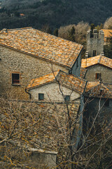 old houses roofs in the old town of san marino city with stone walls details and plants 