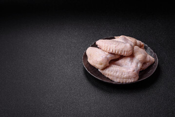 Naklejka premium Raw chicken wings with salt, spices and herbs