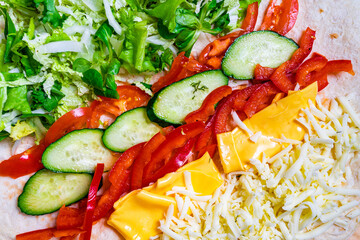 Freshly prepared wrap filled with colorful vegetables and cheese
