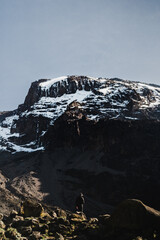 A single person standing in front of the huge mountain Kilimanjaro in Tanzania Africa