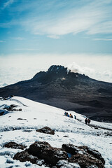 A mountain peak covered in clouds as seen from Uhuru Peak of Mount Kilimanjaro in Tanzania Africa