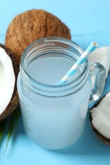 Mason jar with coconut water with nuts on wooden table
