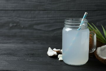 Mason jar with coconut water with nuts on wooden table
