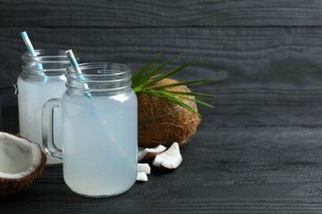 Mason jars with coconut water with nuts on wooden table