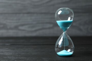 Modern hourglass on wooden background. Hourglass time concept for business deadline, urgency and...