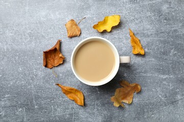 Autumn composition with leaves and cup of coffee on gray background