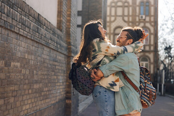 Loving hipster couple is hugging on city street downtown. Copy space