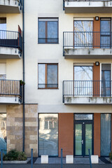 modern apartment building facade with balconies and glass doors
