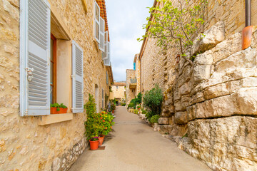 Fototapeta premium A picturesque, narrow stone alley in the medieval hilltop village of Gourdon, in the Alpes-Maritime section of Southern France. 