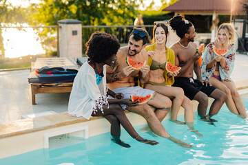 Friends eating watermelon by the poolside during summer vacation