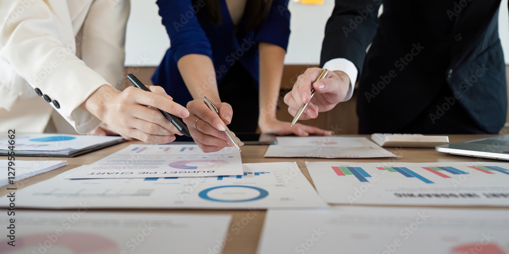 Poster close-up of hands analyzing financial documents and charts in a collaborative business environment.