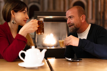 happy couple enjoying coffee and tea at bar at night