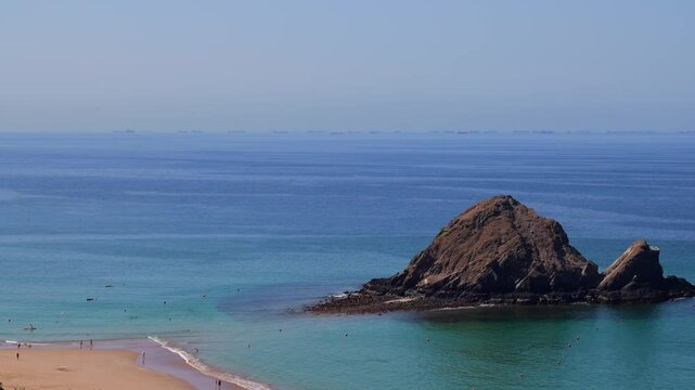 Snoopy Island in Fujairah, UAE. Aerial view of the beach with turquoise waters, a rocky island and a resort nearby