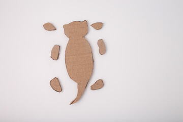 Step in the creative process of making a cardboard otter, showing initial layout with body, tail,...