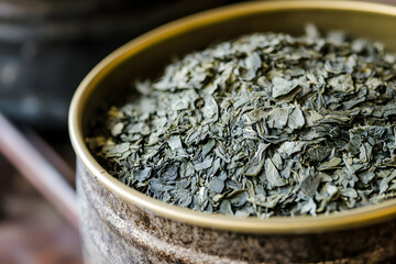 Close-up of premium dried gyokuro sencha tea leaves in a tin container, ideal for promoting quality tea products