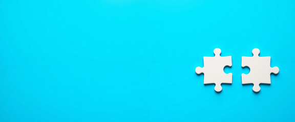 Obraz premium Puzzle pieces symbolizing teamwork and collaboration on a bright blue background, representing connection and unity in problem-solving