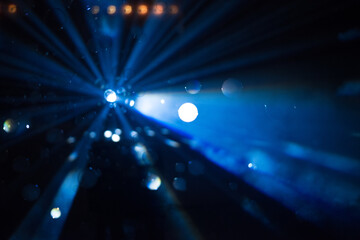 Intense blue beam illuminating a cloud of smoky soap bubbles indoors