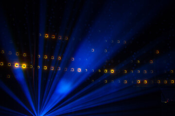 A cold blue light illuminating a dark indoor space with yellow pulsing orbs in the background