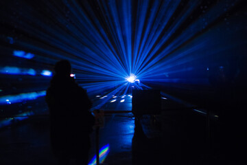 A viewer watching a mesmerizing blue light beam that splits into multiple separate beams