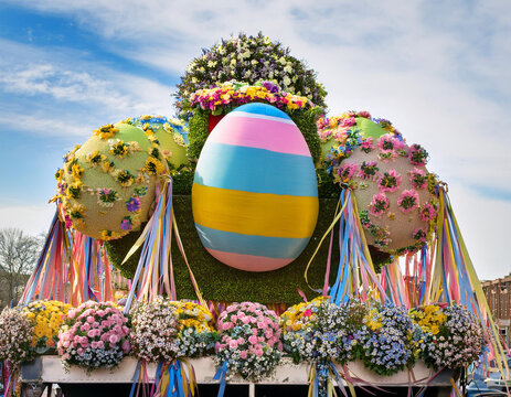 A festive Easter parade float adorned with flowers, ribbons, and oversized Easter eggs.
